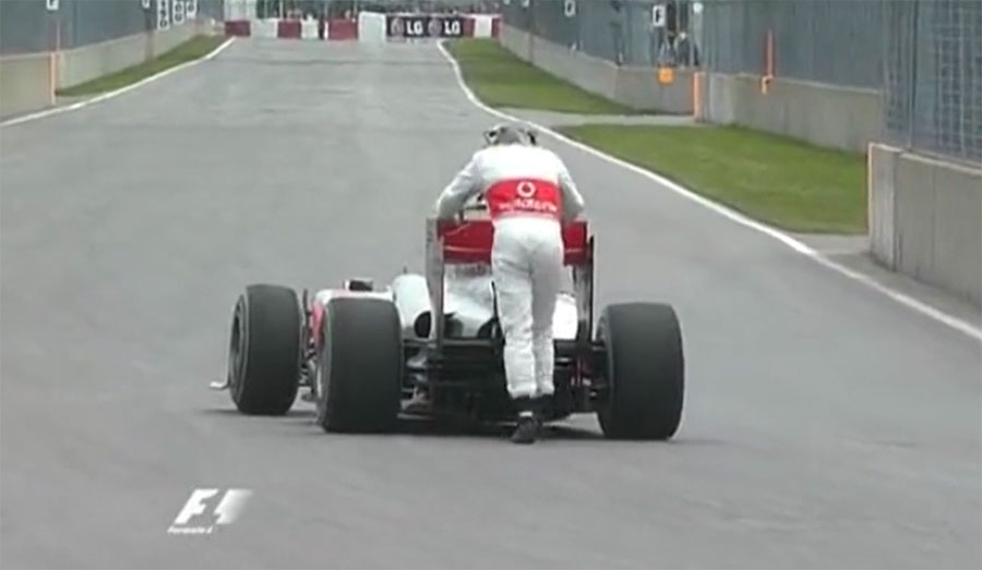 Lewis Hamilton pushes his McLaren MP4-25 to the paddock on account of low fuel