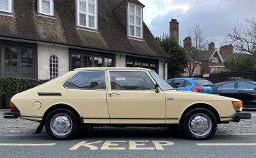 A classic 1981 Saab 900 GLS in pristine condition, showcased in a charming urban setting, illustrating the timeless elegance of Swedish automotive design.
