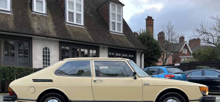 A classic 1981 Saab 900 GLS in pristine condition, showcased in a charming urban setting, illustrating the timeless elegance of Swedish automotive design.