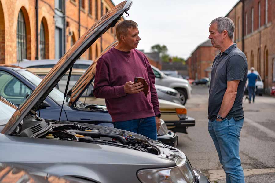 Saab enthusiasts sharing their passion and stories in front of Gasoline Juice - where every Saab conversation becomes a memorable moment.