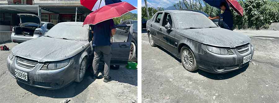 The Saab 9-5 in Guangfu immediately after the floodwaters withdrew, still coated in silt as the owners inspect the car under the midday sun.