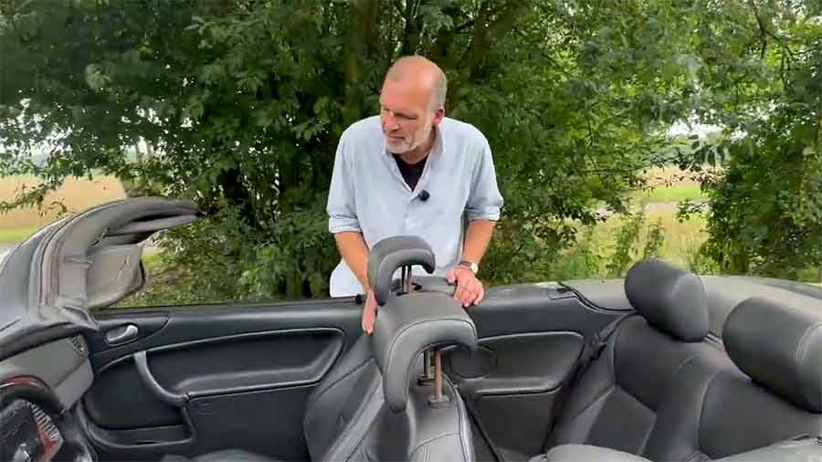 A Summer Car You’ll Actually Drive: Saab 9-3 Convertible, As Seen by a No-Nonsense Enthusiast 2 Reviewer examining the interior of a Saab 9-3 Convertible with the top down
