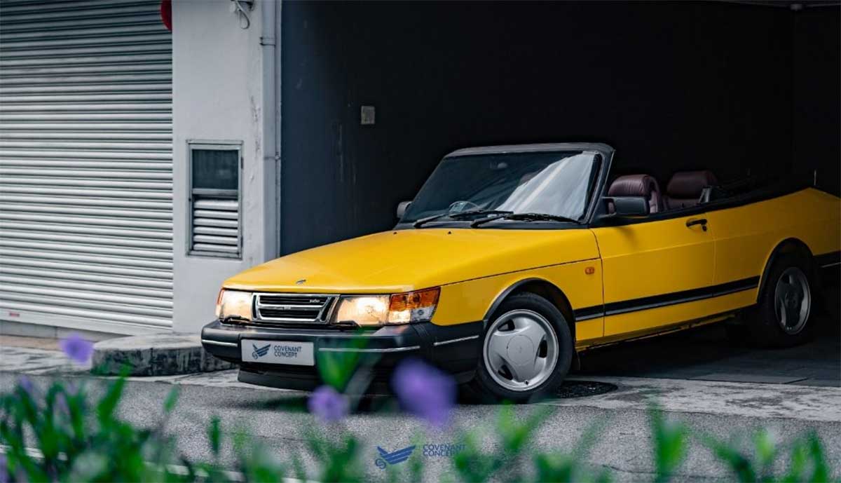 Experience the thrill of driving in style with the Lynx Yellow SAAB 900 Convertible.