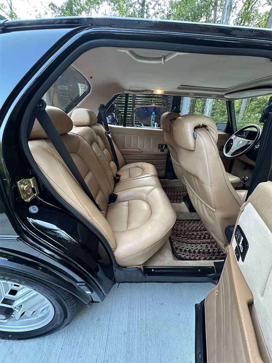 1985 Saab 900 Turbo sedan rear seating in tan Sierra leather, showing contoured design and well-preserved condition.