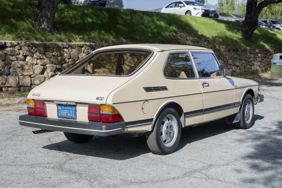 Rear side view of a well-preserved 1983 Saab 900, highlighting the impeccable chassis with no signs of corrosion, a testament to the car's enduring quality and care.