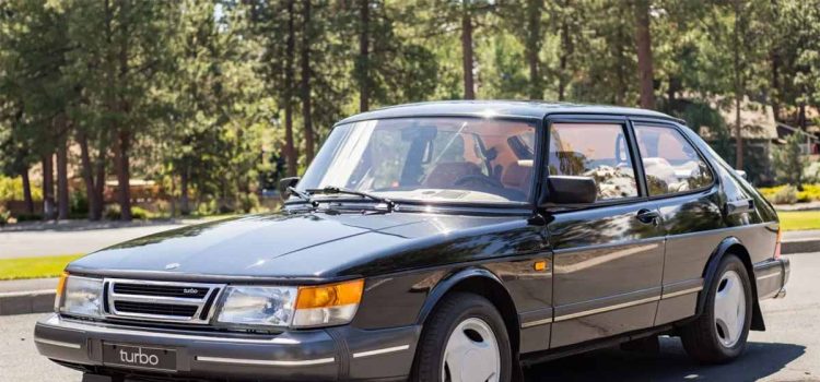 Front three-quarter view of a Black 1988 Saab 900 Turbo hatchback with Sierra leather interior, photographed outdoors.