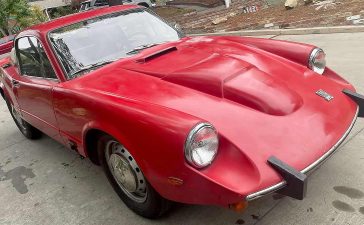 The 1969 Saab Sonett V4 on Bring a Trailer, showing its clamshell hood and signature V4 bulge that marked Saab’s pivot from two-stroke to four-stroke power.