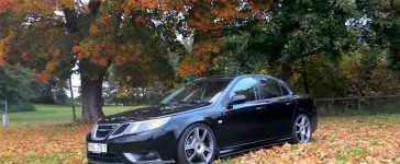 Lowered Saab 9-3 Turbo X parked on autumn leaves with upgraded wheels and a black exterior.