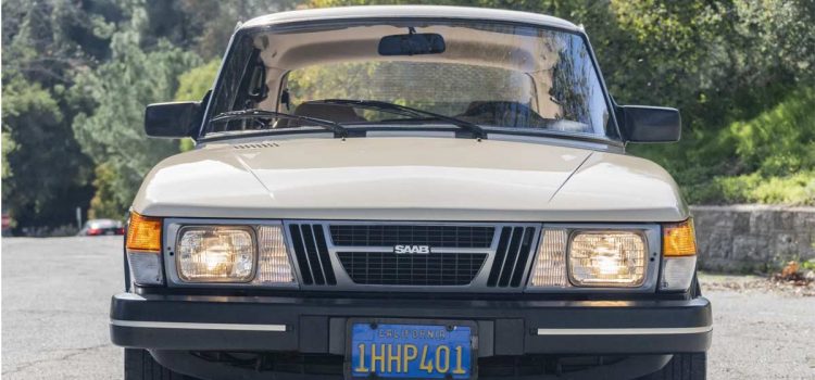 1983 Saab 900 in Ivory, showcasing its classic silhouette and timeless design on a serene road, embodying the joy of driving a vintage masterpiece.