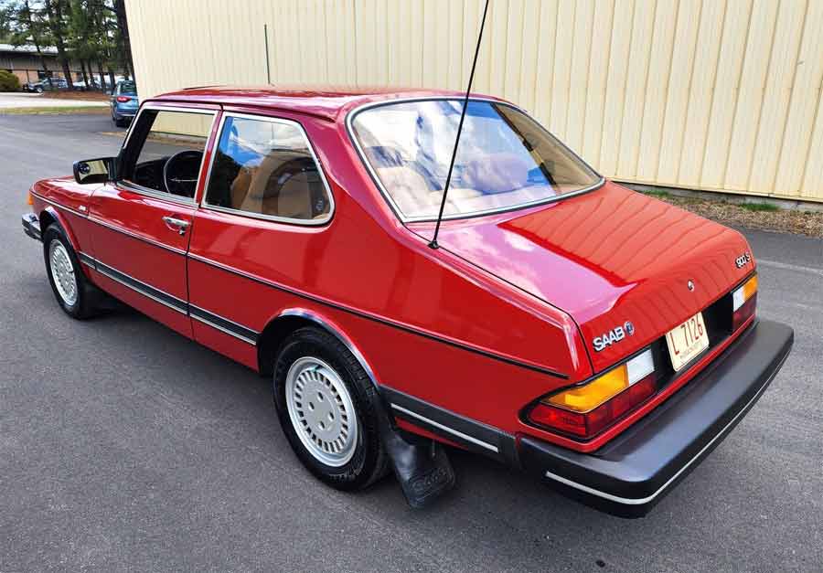 Showcasing the iconic rear hatch and clean lines of the 1985 SAAB 900S Coupe, this image captures the car's well-preserved state and enduring design, complete with the original wheels and distinctive tail lights.