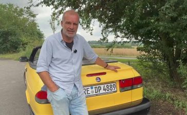 A Summer Car You’ll Actually Drive: Saab 9-3 Convertible, As Seen by a No-Nonsense Enthusiast 8 German automotive enthusiast standing beside a yellow Saab 9-3 Convertible during a summer review