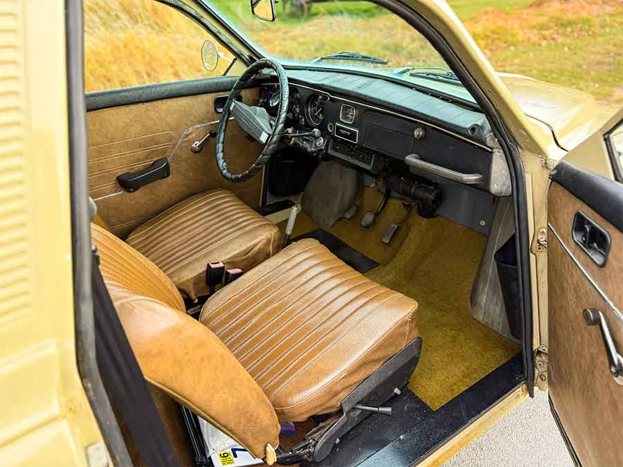 Interior view of a beige 1971 Saab 95 Wagon showing brown vinyl seats, dashboard, column-shift manual, and simple instrumentation