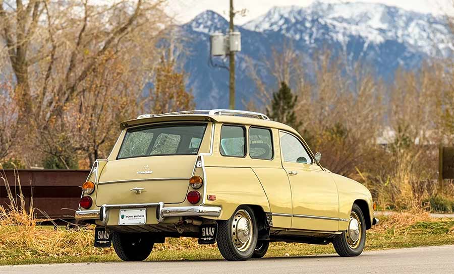 Rear three-quarter view of a beige 1971 Saab 95 Wagon showing tail fins, liftgate, steel wheels, and roof rack during a Bring a Trailer listing