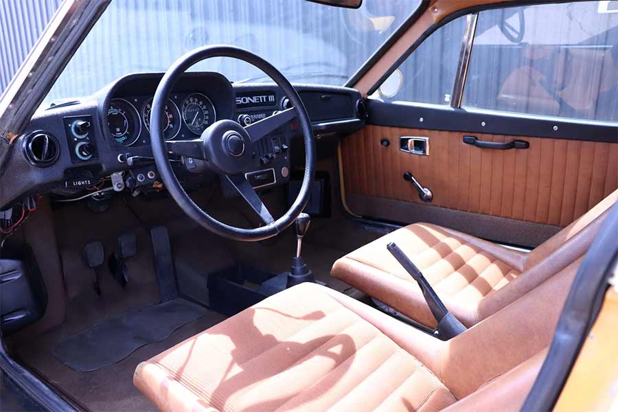 The interior of this Sonett III stays true to its era, featuring factory brown vinyl and cloth seats, a VDO gauge cluster with a central tach, and even retains its period AM/FM radio — a retro cockpit that echoes Saab’s unique blend of function and flair.