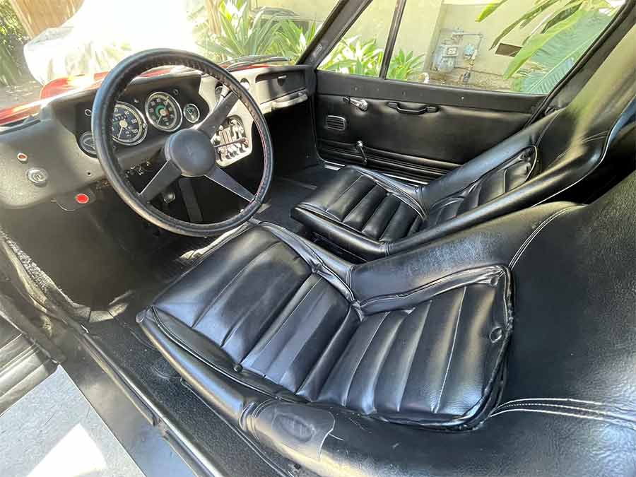 1969 Saab Sonett V4 interior showing black vinyl bucket seats, three-spoke steering wheel, and VDO gauges.
